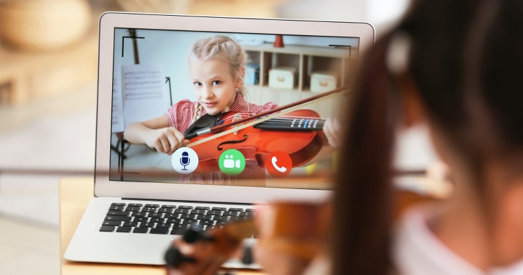 little girl studying music with her friend online home